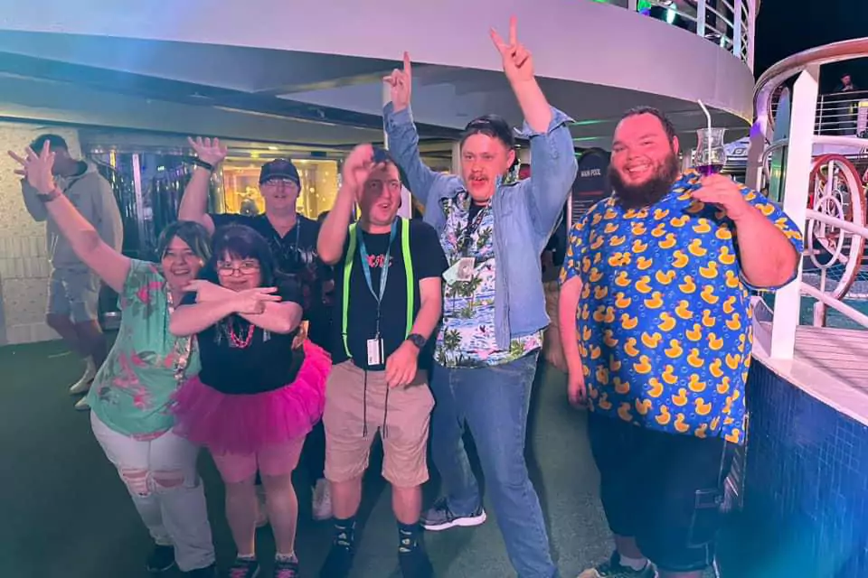 Group of friends having fun and smiling while raising their hands