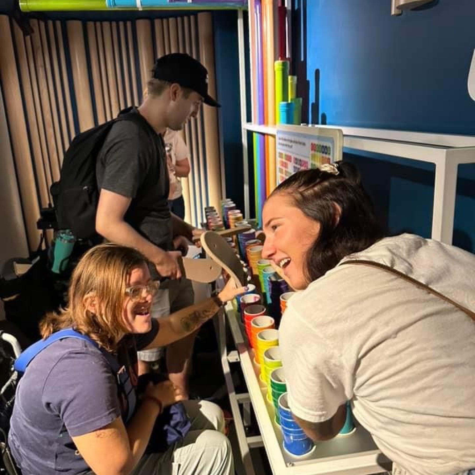 A disabled woman and her support worker looking at colorful pipes