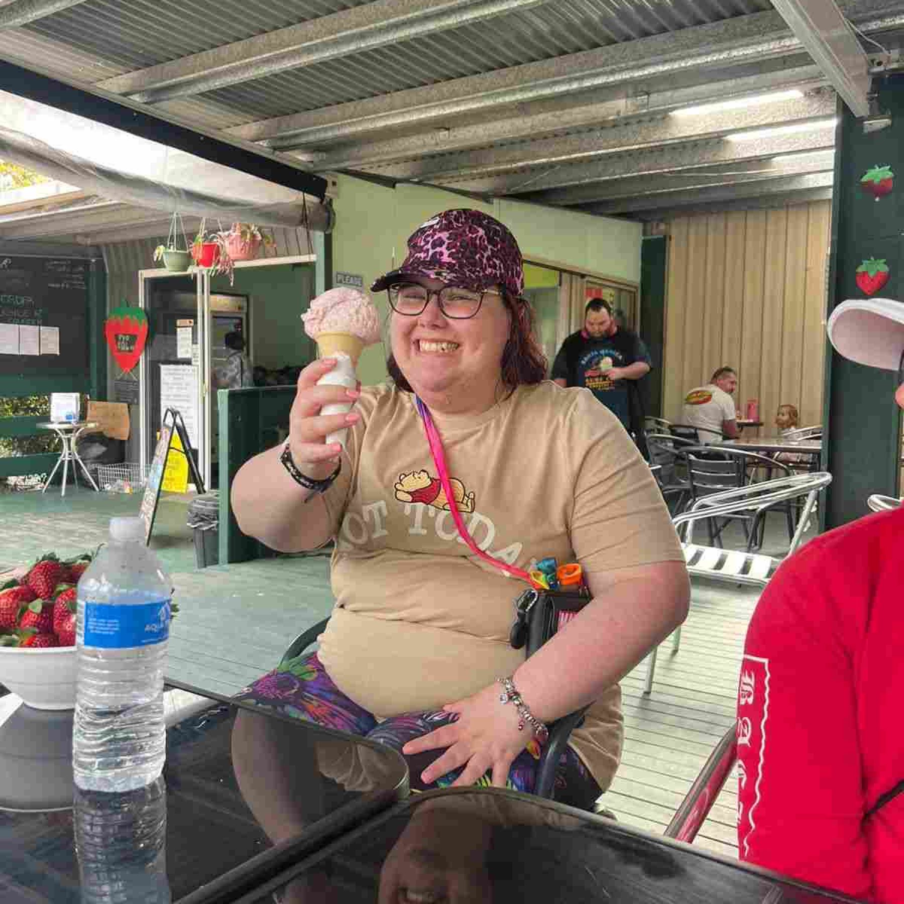 A woman smiling while showing her ice cream