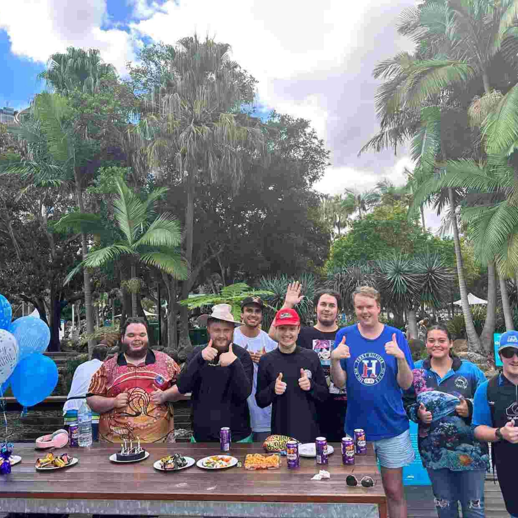 Group of people smiling and doing a thumbs up