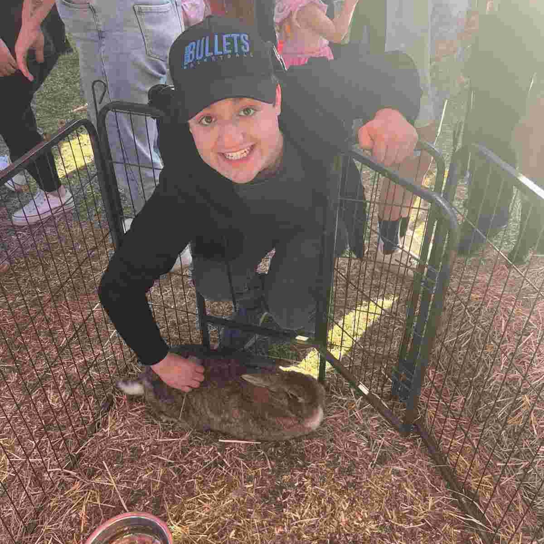A man smiling while holding a rabbit