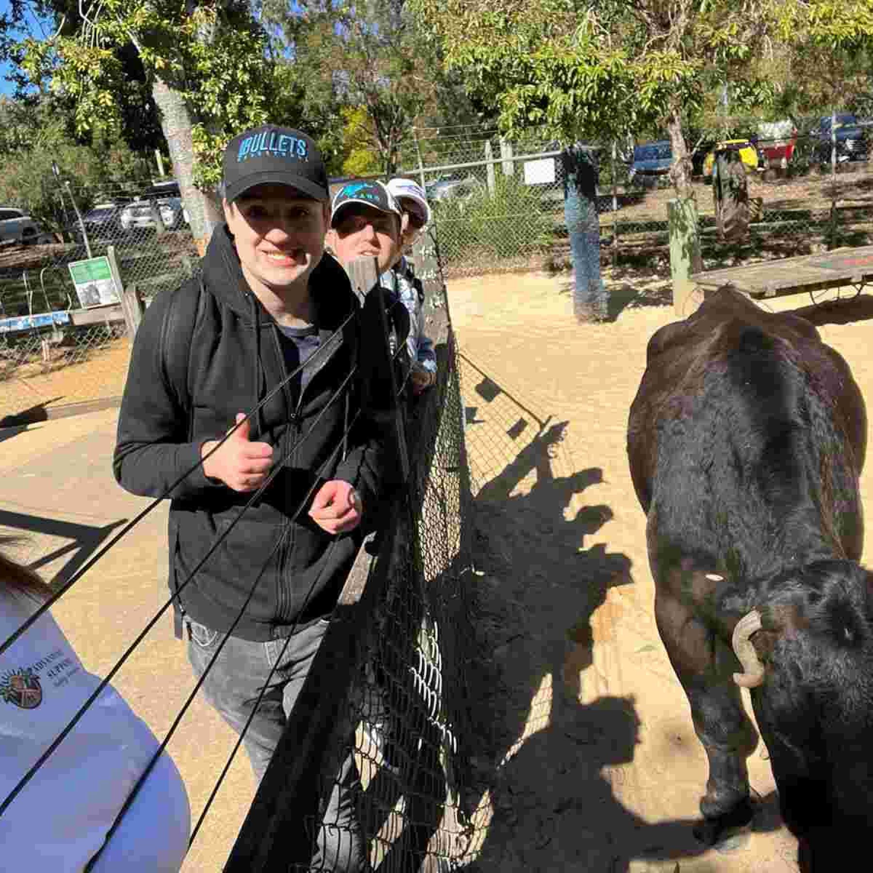 Group of people smiling in front of an animal